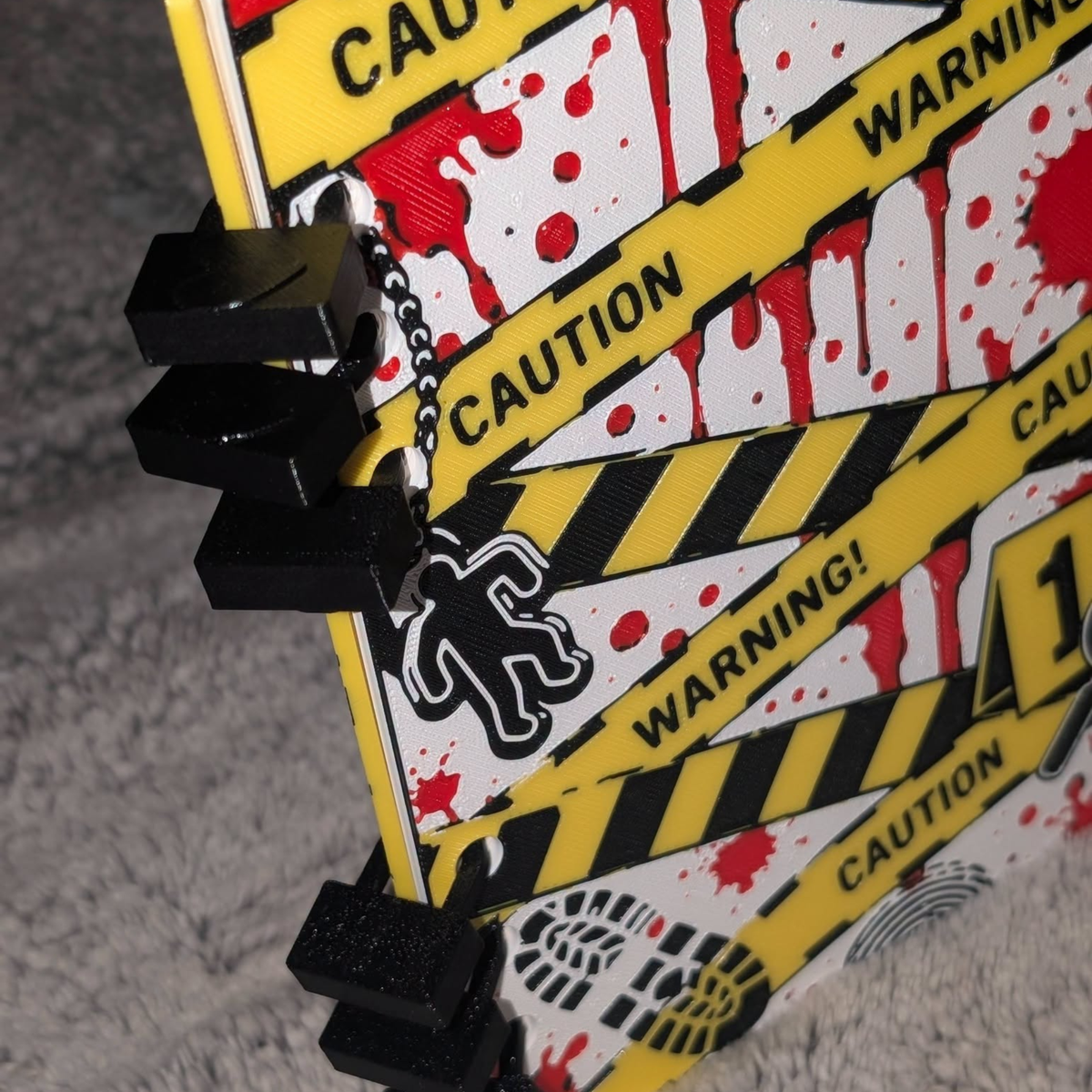 Close-up of black padlock-style bindings on a yellow crime-scene journal